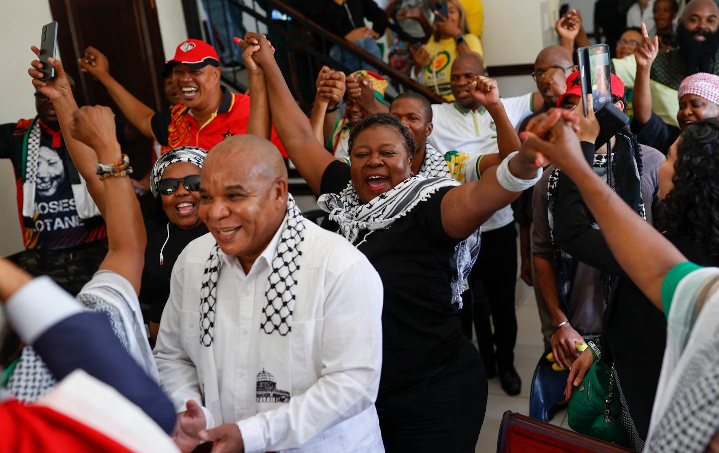 Pro-Palestinian supporters react in celebration after watching the International Court of Justice deliver its decision following a hearing of the case against Israel brought by South Africa in The Hague at the Embassy of Palestine in Pretoria on January 26, 2024.