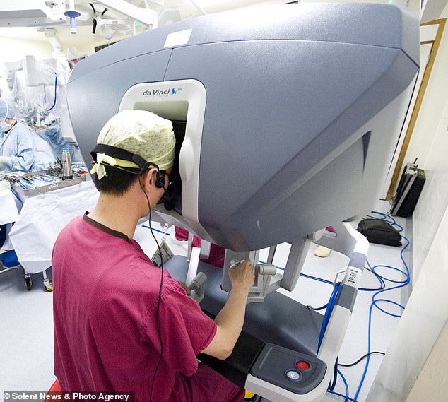 Ärzte, die die Operation mit dem Roboter durchführen, bedienen die Arme hinter einer Konsole