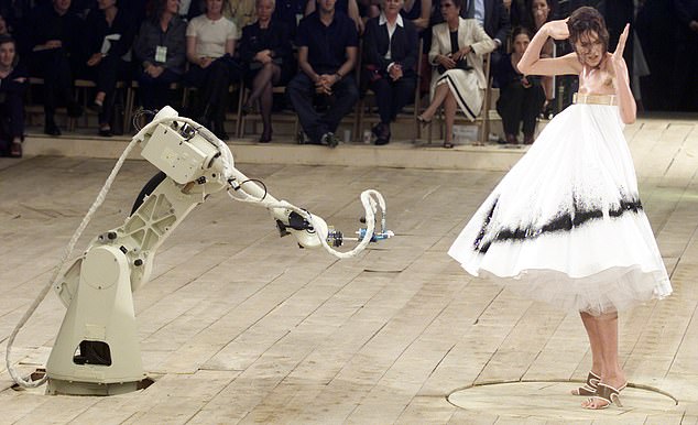 Model Shalom Harlow lässt ihr Kleid bei der Alexander-McQueen-Show 1998 von Robotern besprühen