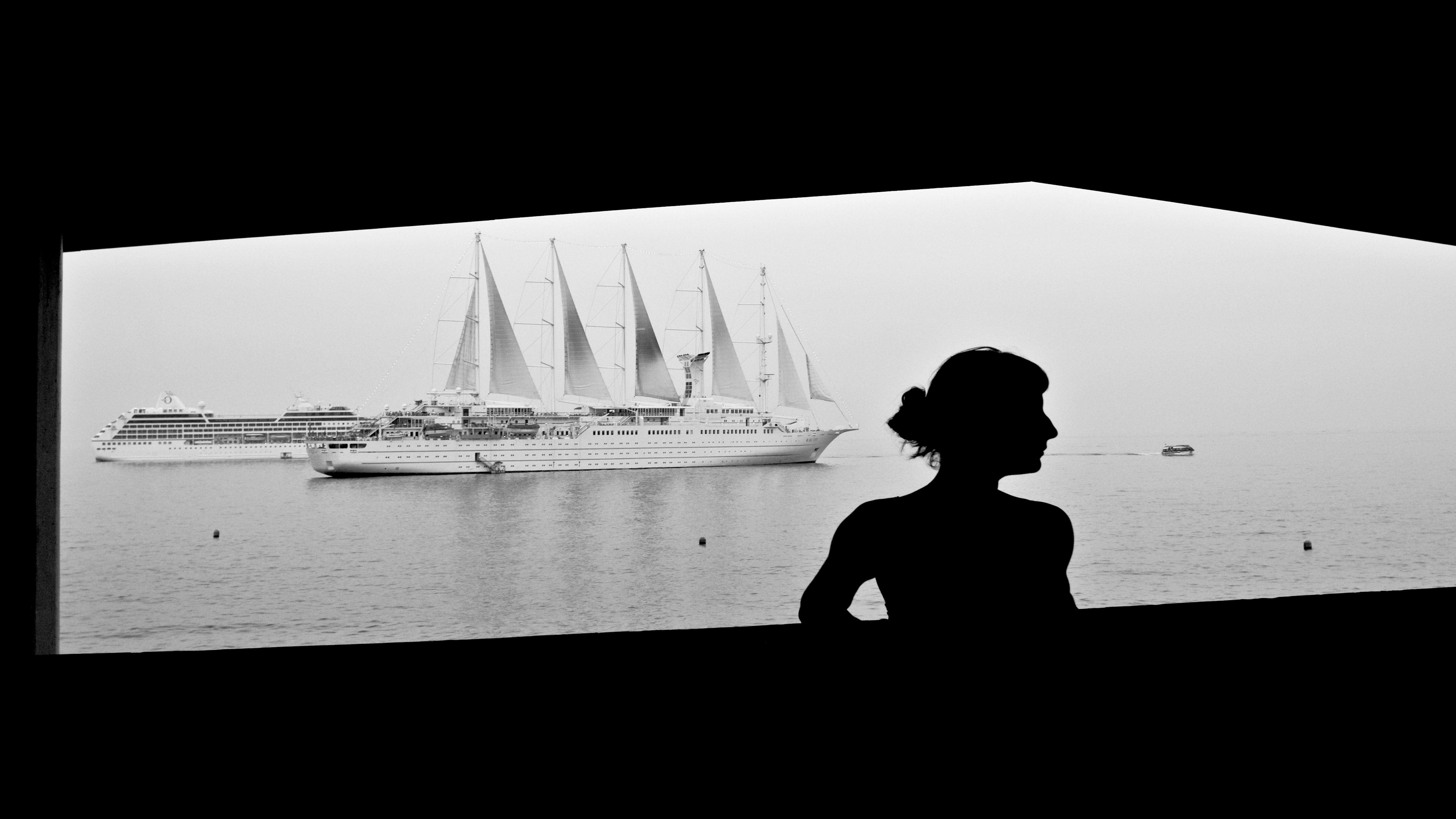 Eine Frau posiert vor einem Kreuzfahrtschiff
