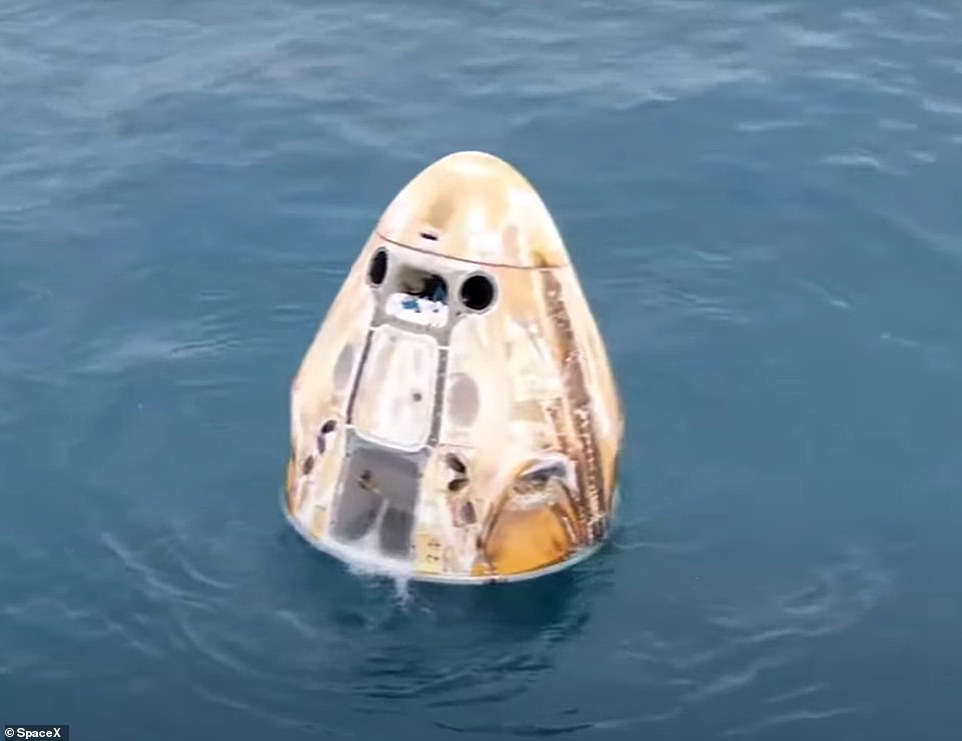 Die SpaceX Dragon Crew-Kapsel schaukelte im Atlantik vor der Küste von Daytona, Florida, nachdem sie heruntergespritzt war.  Seine Oberfläche war durch die enorme Hitze, die beim Wiedereintritt entstand, versengt