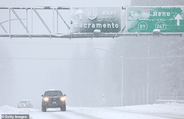 Vehicles drive as snow falls north of Lake Tahoe in the Sierra Nevada mountains