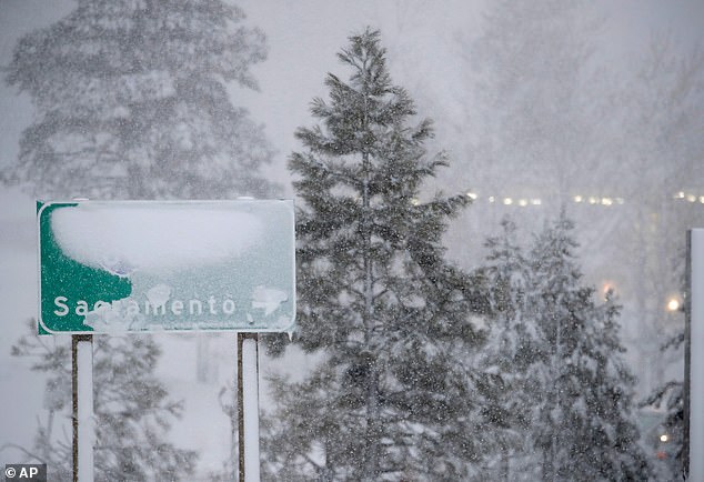 A sign for Interstate 80 westbound is seen covered with snow in Truckee, California, just before authorities shut down 100 miles of freeway