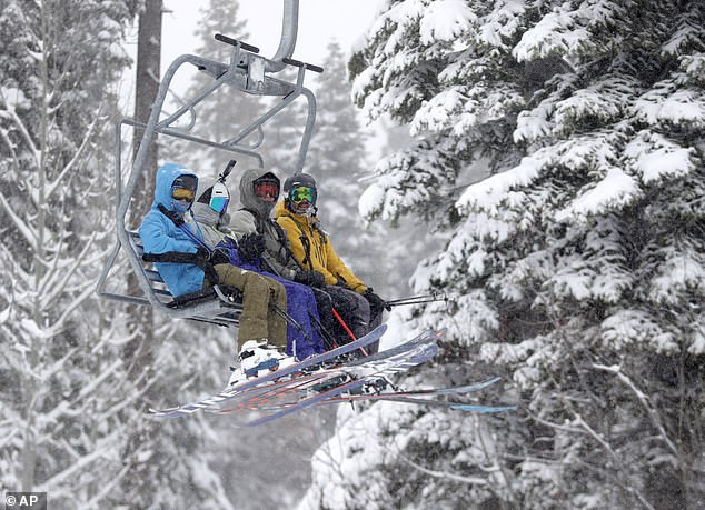 Skiers ride the Village Express chairlift at Northstar California Resort as it snows in Truckee before the ski resorts were shuttered