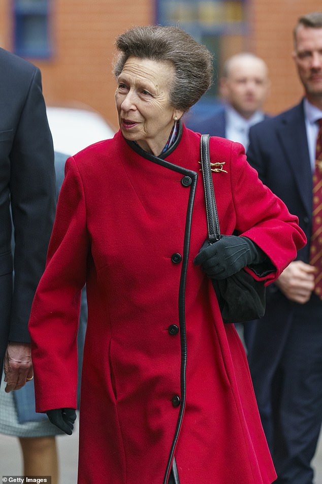 Die Königin begeisterte in einem leuchtend roten Mantel, den sie mit schwarzen Handschuhen und einer schicken goldenen Brosche kombinierte