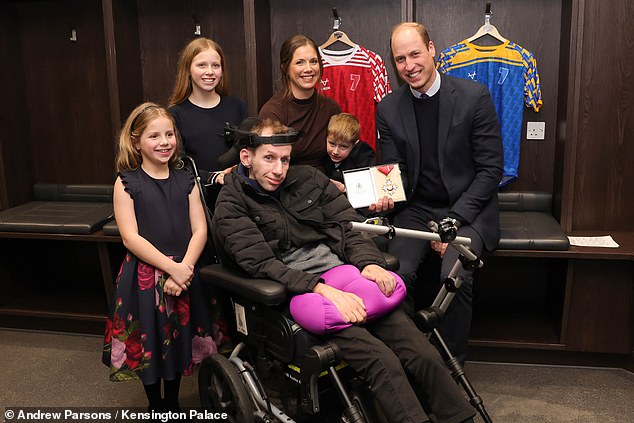 Rob und seine Familie im Bild mit Prinz William, der der Sportlegende einen CBE überreichte