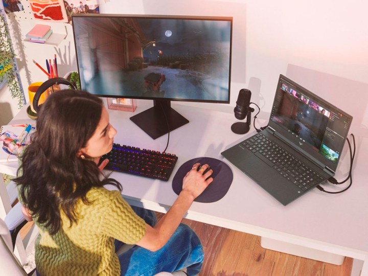 Ein Mädchen spielt Spiele auf dem 15,6-Zoll-Gaming-Laptop HP Victus mit angeschlossenem externen Display.
