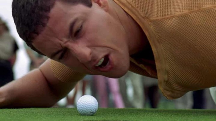 Adam Sandler liegt in einer Szene aus „Happy Gilmore“ am Boden und schreit einen Golfball an.