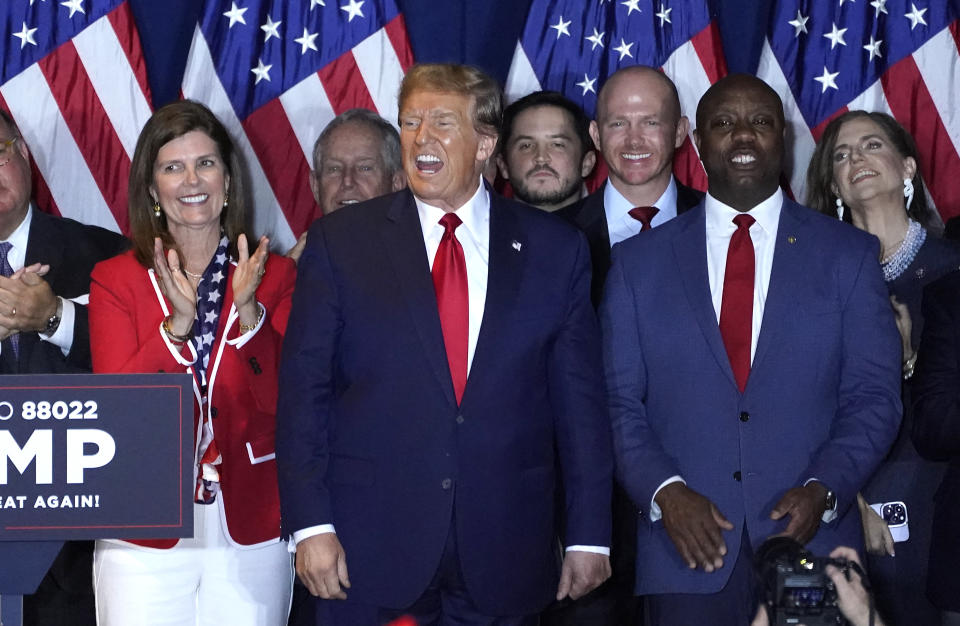 Der ehemalige Präsident Donald Trump steht zusammen mit mehreren anderen Personen auf der Bühne einer Wahlnachtparty.