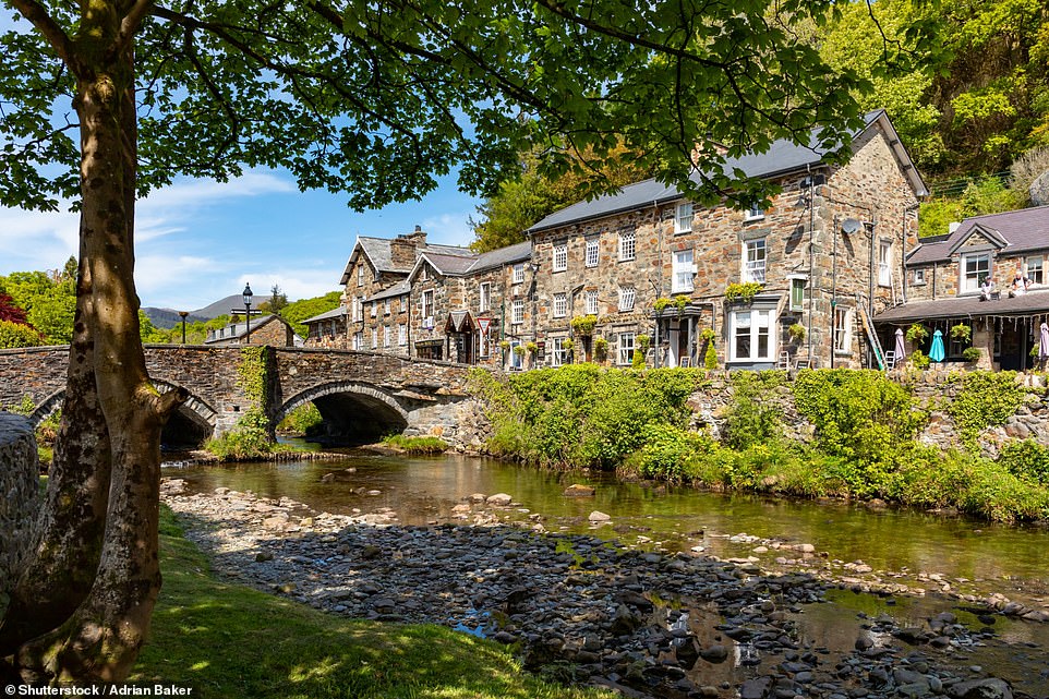 13. BEDDGELERT, SNOWDONIA, WALES: 'Nestled in the foothills of Snowdon, this village is as scenic as you can get,' says Big 7 Travel. The village is 'a pretty smattering of grey-stone cottages, cosy pubs, and craft shops' while the 'dramatic' surrounding scenery 'stretches up to the mountaintop, which you can take in from the village¿s stone bridge'
