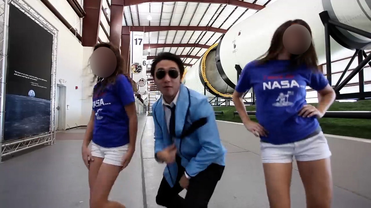 Der Screenshot im NASA-Johnson-Style zeigt Eric Sim, wie er zwischen zwei Frauen tanzt