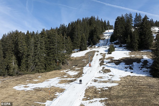 Skifahrer nutzen einen Lift auf einer teilweise schneebedeckten Skipiste im Alpenresort Les Mosses in Ormont-Dessous, Schweiz, 6. Februar 2024. Mildes Wetter in den letzten Tagen in den Schweizer Alpen störte die Aktivität alpiner Skigebiete