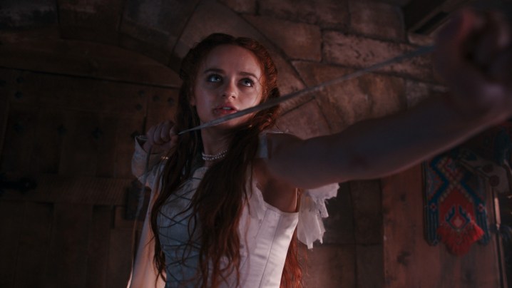 Joey King steht im Schatten und hält ein Schwert in einer Szene aus „Die Prinzessin“.