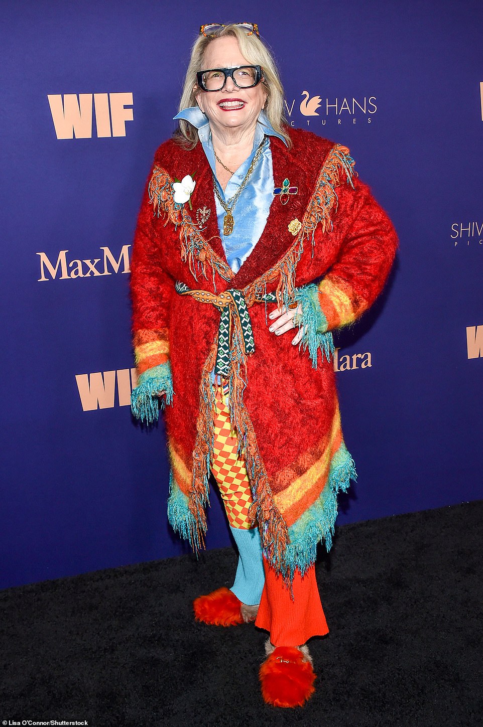 Laura Karpman put on a bold display in bright colors and mixed patterns as the Oscar-nominated composer turned up in the most eccentric outfit of the night. She wore a colorful cozy cardigan with a tie around the waist layered over patterned bellbottom pants and a sky blue polo top