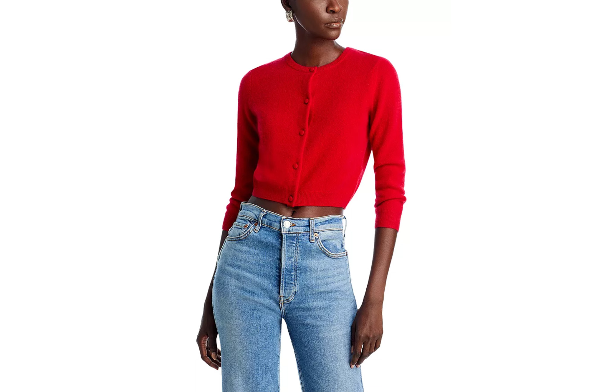 Ein Model in einer roten Strickjacke und Jeans