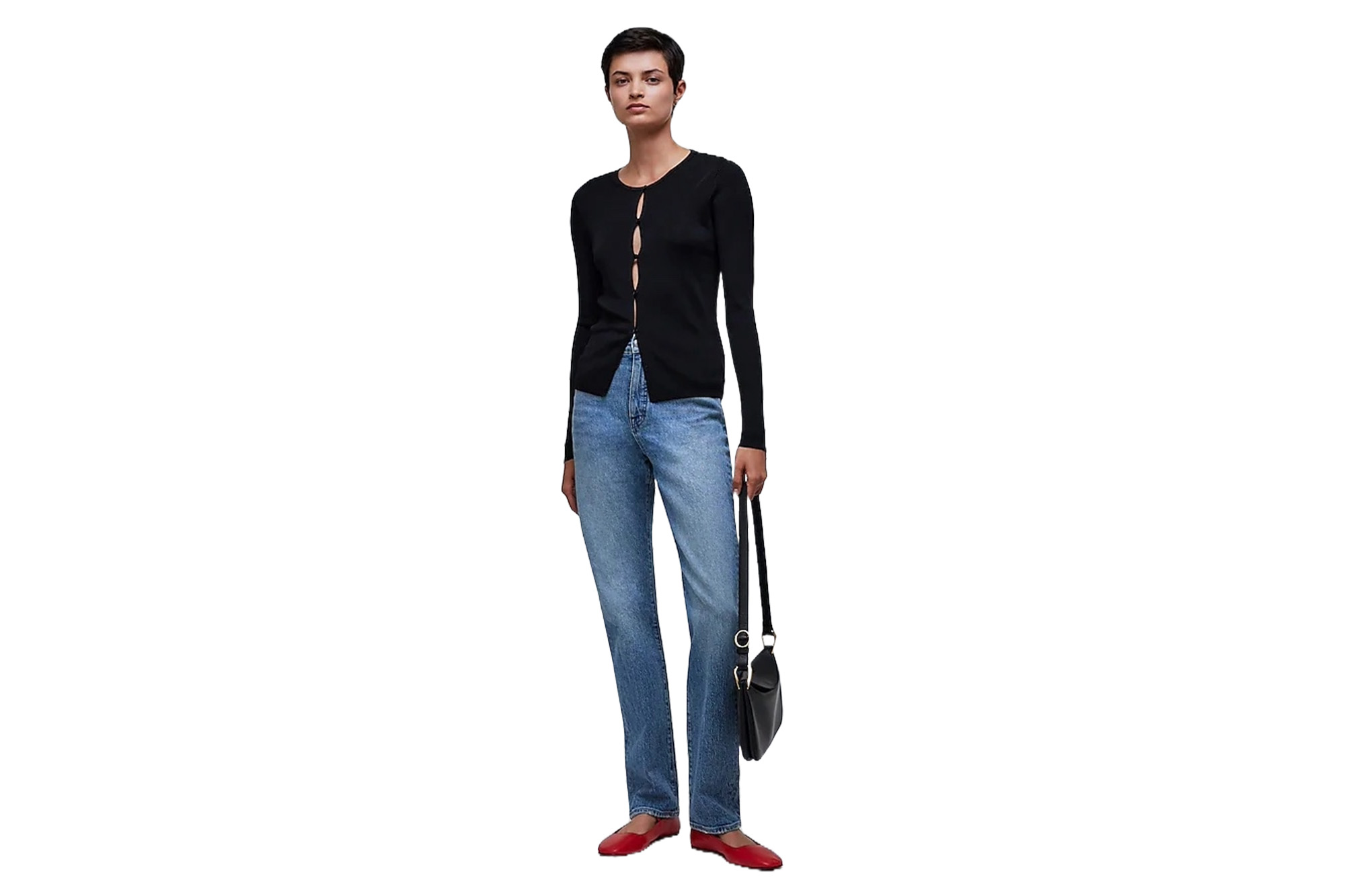 Ein Model in einem schwarzen Pullover und Jeans