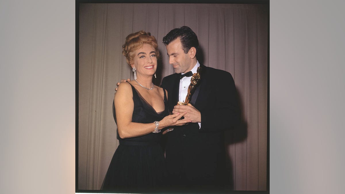 Joan Crawford hält einen Oscar mit einem männlichen Star in der Hand