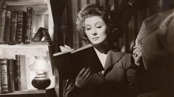 Begrüßen Sie Garson beim Lesen eines Buches in einer Schwarz-Weiß-Szene aus dem Film Mrs. Miniver