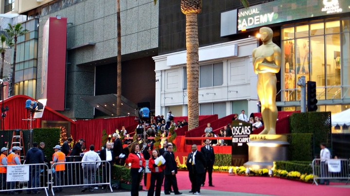 Die Außenseite der Oscar-Verleihung zeigt herumlaufende Menschen und den roten Teppich.