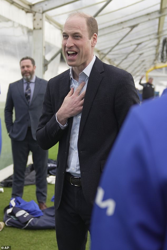 Prince William laughs as he speaks to Surrey County Cricket Club players at the Oval on Friday