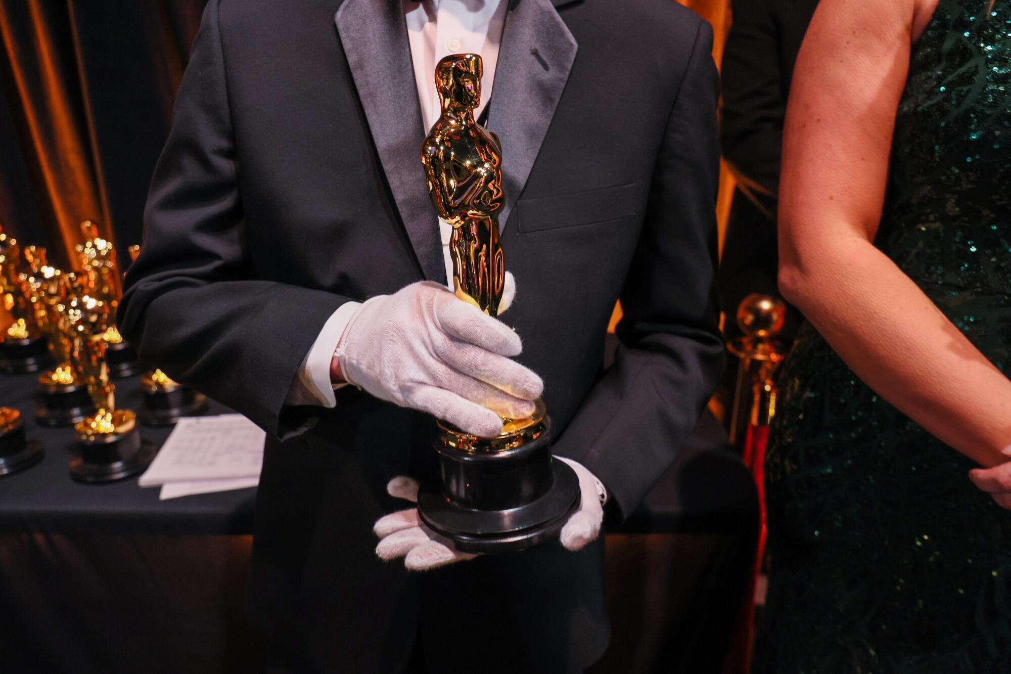 Ein Mann hält eine Oscar-Trophäe in der Hand.