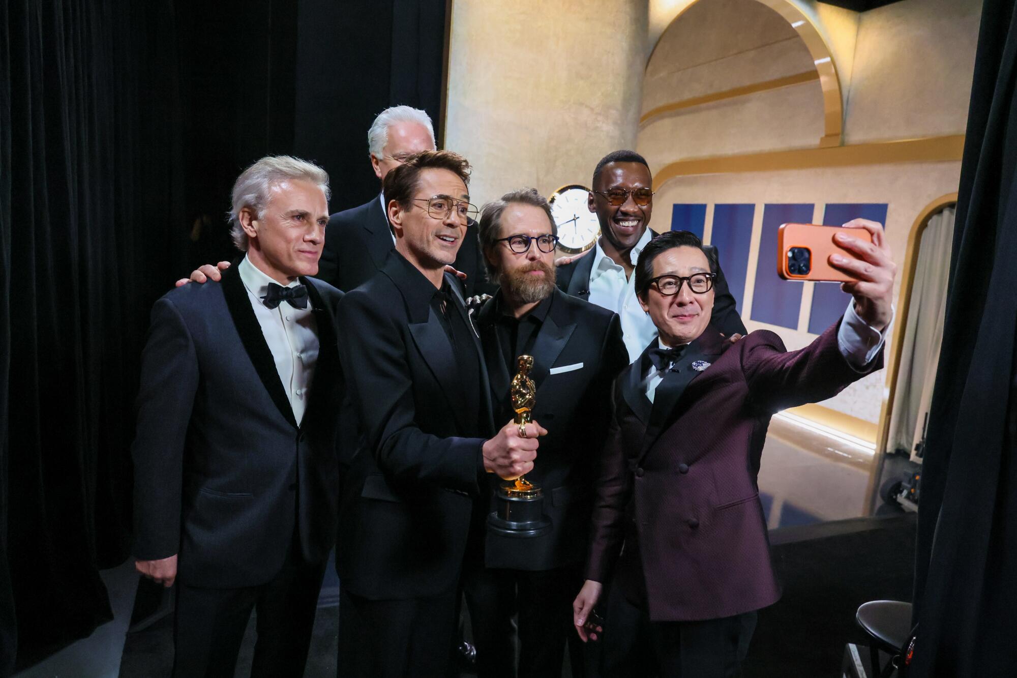 Nebendarsteller-Gewinner Robert Downey Jr. umgeben von Moderatoren hinter der Bühne während der 96. Oscar-Verleihung.