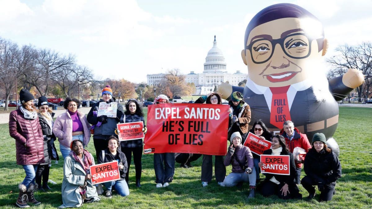 Eine Gruppe von Demonstranten mit einem riesigen Ballon, der den Kongressabgeordneten George Santos darstellt, steht vor dem US-Kapitol für ein Foto