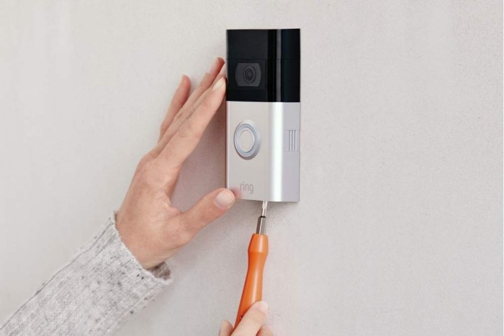 Someone installing the Ring Video Doorbell 3 with a screwdriver.