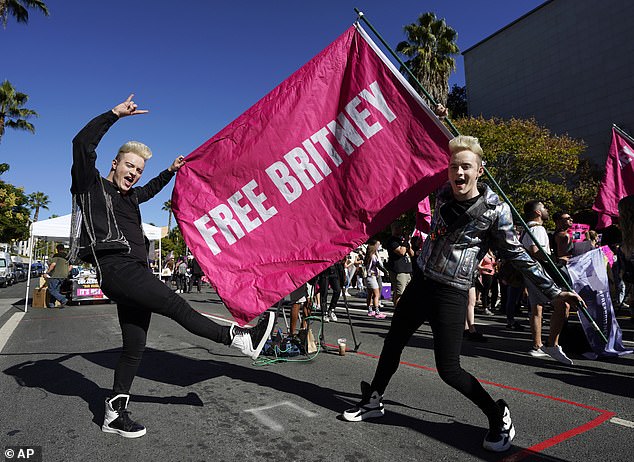 Twins Edward, right, and John Grimes of Dublin, Ireland, hold a "Free Britney" flag outside a hearing concerning the pop singer's conservatorship at the Stanley Mosk Courthouse in 2021, in Los Angeles