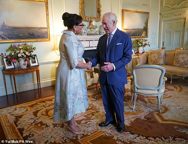 The King laughs during an audience with Baroness Scotland at Buckingham Palace yesterday