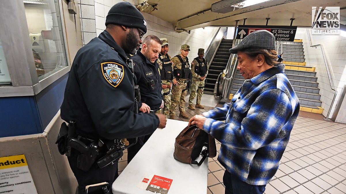 Mitglieder des NYPD und der Nationalgarde führen stichprobenartige Taschendurchsuchungen im New Yorker U-Bahn-System durch