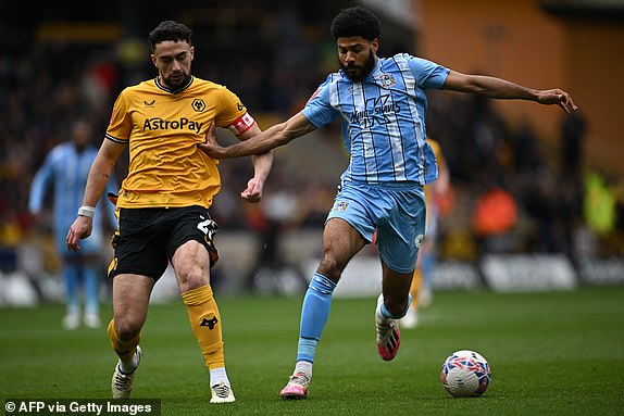 Wolverhampton Wanderers' English defender #23 Max Kilman (L) vies with Coventry City's English striker #09 Ellis Simms (R) during the English FA Cup Quarter-final football match between Wolverhampton Wanderers and Coventry City at the Molineux stadium in Wolverhampton, central England on March 16, 2024. (Photo by Paul ELLIS / AFP) / RESTRICTED TO EDITORIAL USE. No use with unauthorized audio, video, data, fixture lists, club/league logos or 'live' services. Online in-match use limited to 120 images. An additional 40 images may be used in extra time. No video emulation. Social media in-match use limited to 120 images. An additional 40 images may be used in extra time. No use in betting publications, games or single club/league/player publications. /  (Photo by PAUL ELLIS/AFP via Getty Images)