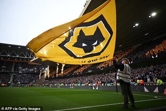 A large Wolves flag is waved in the build-up to kick-off in the English FA Cup Quarter-final football match between Wolverhampton Wanderers and Coventry City at the Molineux stadium in Wolverhampton, central England on March 16, 2024. (Photo by Paul ELLIS / AFP) / RESTRICTED TO EDITORIAL USE. No use with unauthorized audio, video, data, fixture lists, club/league logos or 'live' services. Online in-match use limited to 120 images. An additional 40 images may be used in extra time. No video emulation. Social media in-match use limited to 120 images. An additional 40 images may be used in extra time. No use in betting publications, games or single club/league/player publications. /  (Photo by PAUL ELLIS/AFP via Getty Images)