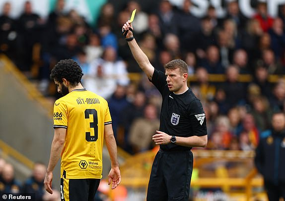 Soccer Football - FA Cup - Quarter Final - Wolverhampton Wanderers v Coventry City - Molineux Stadium, Wolverhampton, Britain - March 16, 2024 Wolverhampton Wanderers' Rayan Ait-Nouri is shown a yellow card by referee Samuel Barrott REUTERS/Molly Darlington