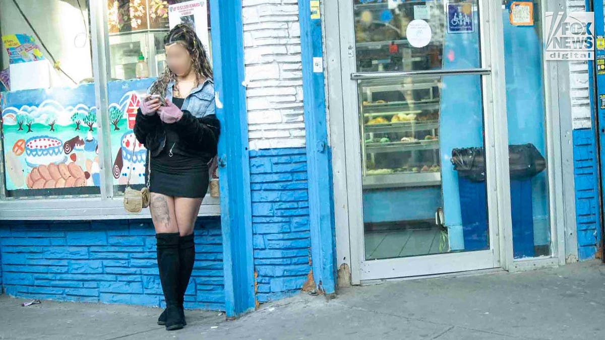 Eine Sexarbeiterin steht auf einer Straße in Queens, New York.