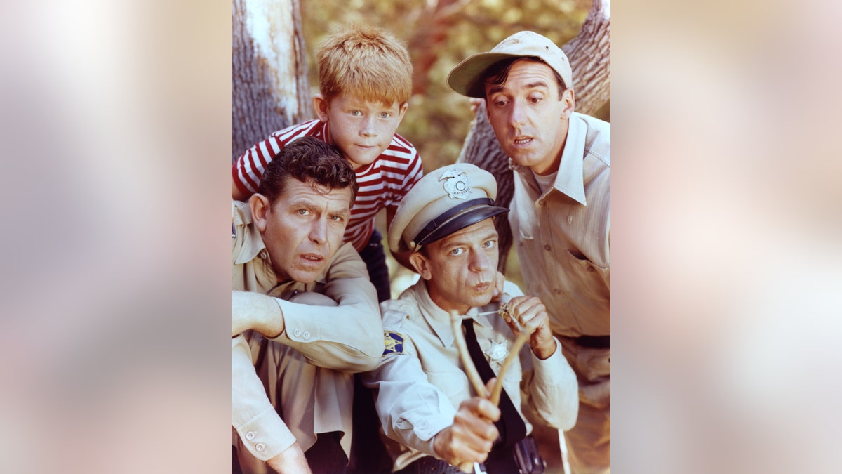   Andy Griffith als Sheriff Andy Taylor, Jim Nabors als Gomer Pyle, Ron Howard als Opie Taylor und Don Knotts als Deputy Barney Fife in der Andy Griffith Show, ca. 1963. 