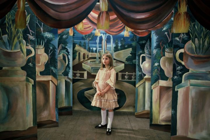 In Alice (1988) steht ein Mädchen mitten in einem Zimmer.