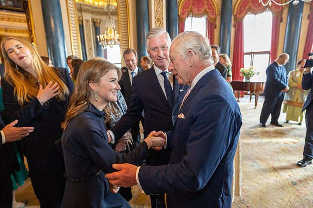 Prinzessin Elisabeth lächelt und schüttelt König Charles bei einer Veranstaltung die Hand