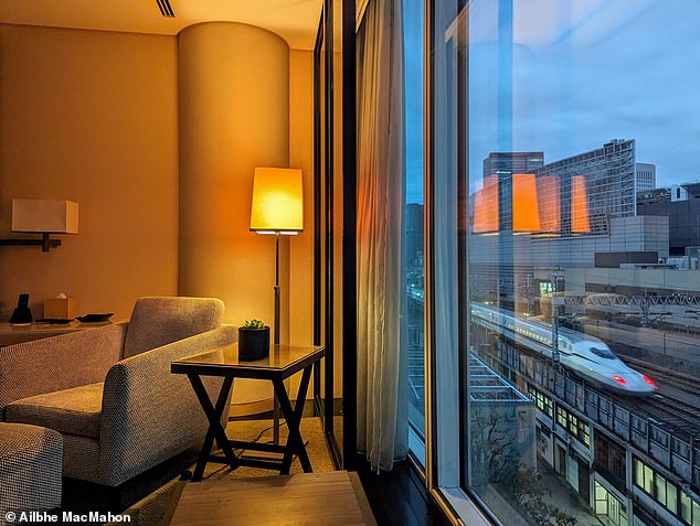 Those who are too relaxed to leave the hotel can sightsee from the comfort of bed, watching as one of Japan’s most iconic sights - the Shinkansen bullet train - parades below the window, says Ailbhe. Pictured: An early morning bullet train passes by her bedroom window
