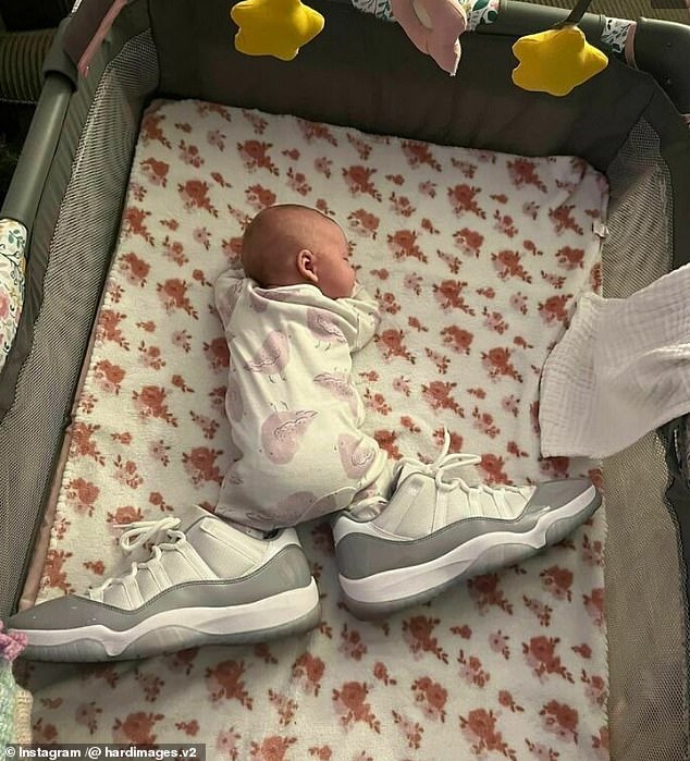 Dieses Baby sieht aus, als hätte es riesige Füße, obwohl in Wirklichkeit die großen Schuhe in das Kinderbett gelegt wurden