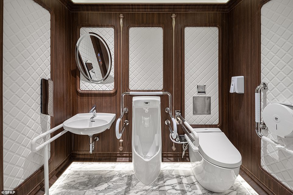 Die barrierefreie Toilette hat einen marmorähnlichen Boden und glänzende Armaturen, wie dieses Bild zeigt
