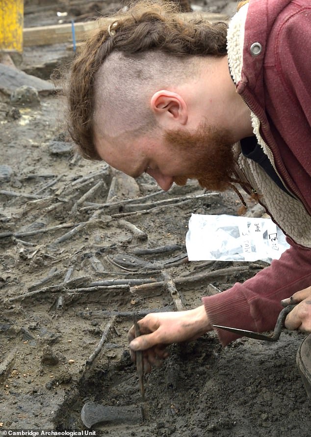 Ein Mitglied der Cambridge Archaeological Unit entdeckte 2016 bei Ausgrabungen auf dem Gelände der Must Farm einen Axtkopf