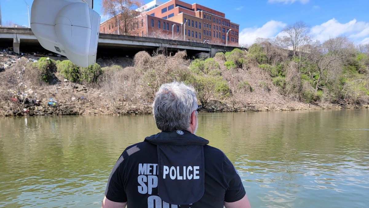 Ein Polizist aus Nashville blickt auf den Cumerland River, während er nach Riley Strain sucht
