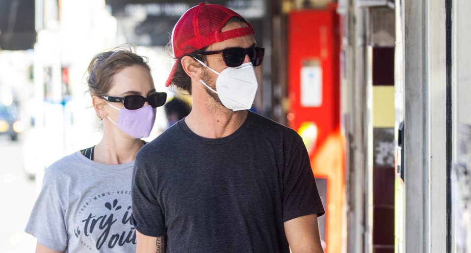 Während eines der Covid-Lockdowns in Australien wird ein Paar mit Masken gesehen. 