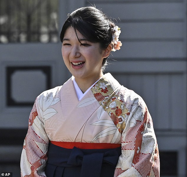 Als Accessoire trug sie eine cremefarbene Handtasche und rosa Blumen in ihren rabenschwarzen Locken, die zu ihrem farbenfrohen Kimono passten