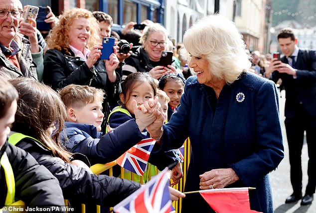 Camilla smiled as she shook the hand of a confident young school child waiting outside of the City Hall