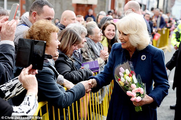Camilla looked pleased to accept two colourful bouquets of tulips from members of the public