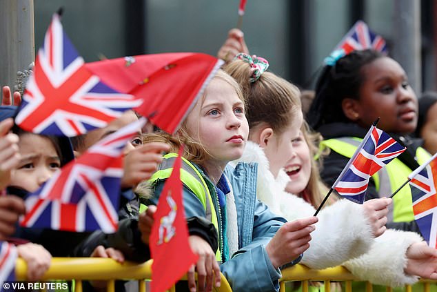 School children patiently waited  for the Queen's arrival with Union Jack flags in their hands