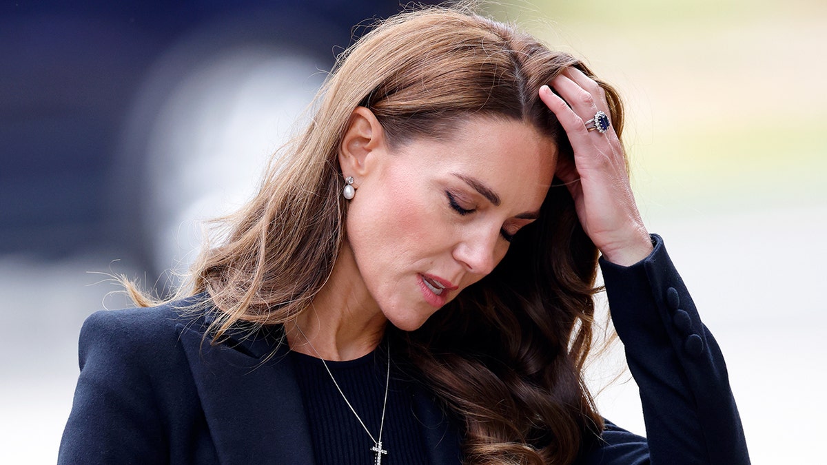 Kate Middleton schaut nach unten und fährt sich gestresst mit der Hand durchs Haar