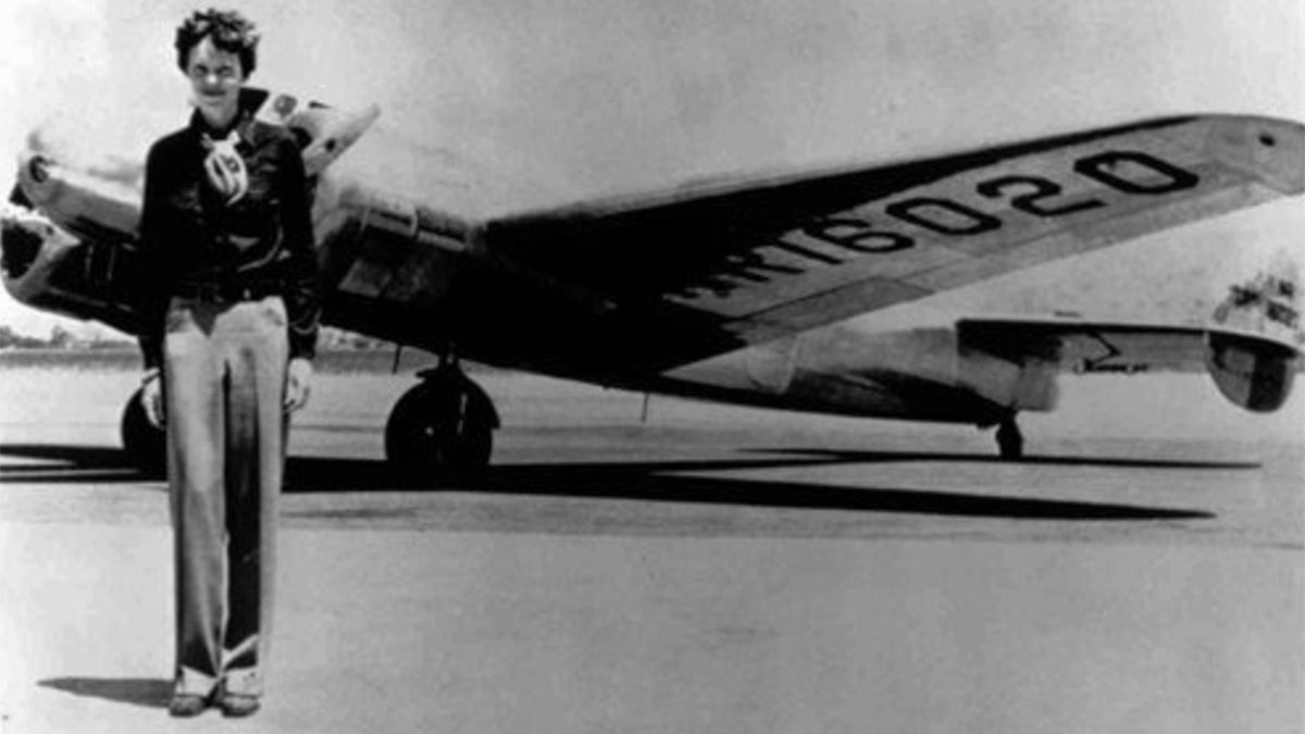 Schwarz-Weiß-Foto von Amelia Earhart vor einem Flugzeug